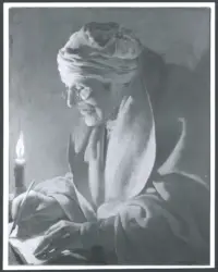 Uomo anziano che scrive a lume di candela